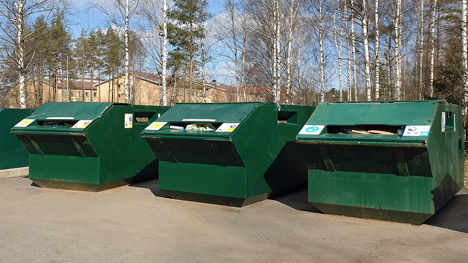 Bild på återvinningsstation med gröna containrar 