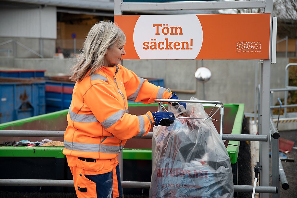 Kvinna som tömmer säcken vid återvinningscentral